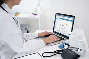 Medical researcher examining data on a computer related to rare disease trials