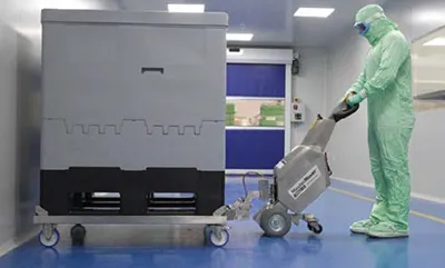 Worker manually moving heavy equipment in a pharmaceutical facility, highlighting safety risks