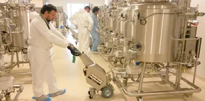 Electric tug moving stainless steel pharma equipment safely in a cleanroom